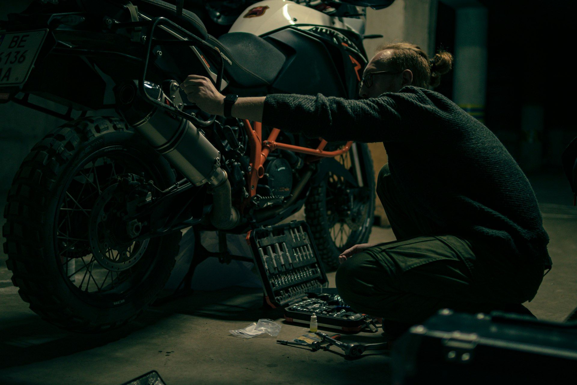 Hands working on a motorcycle in a workshop
